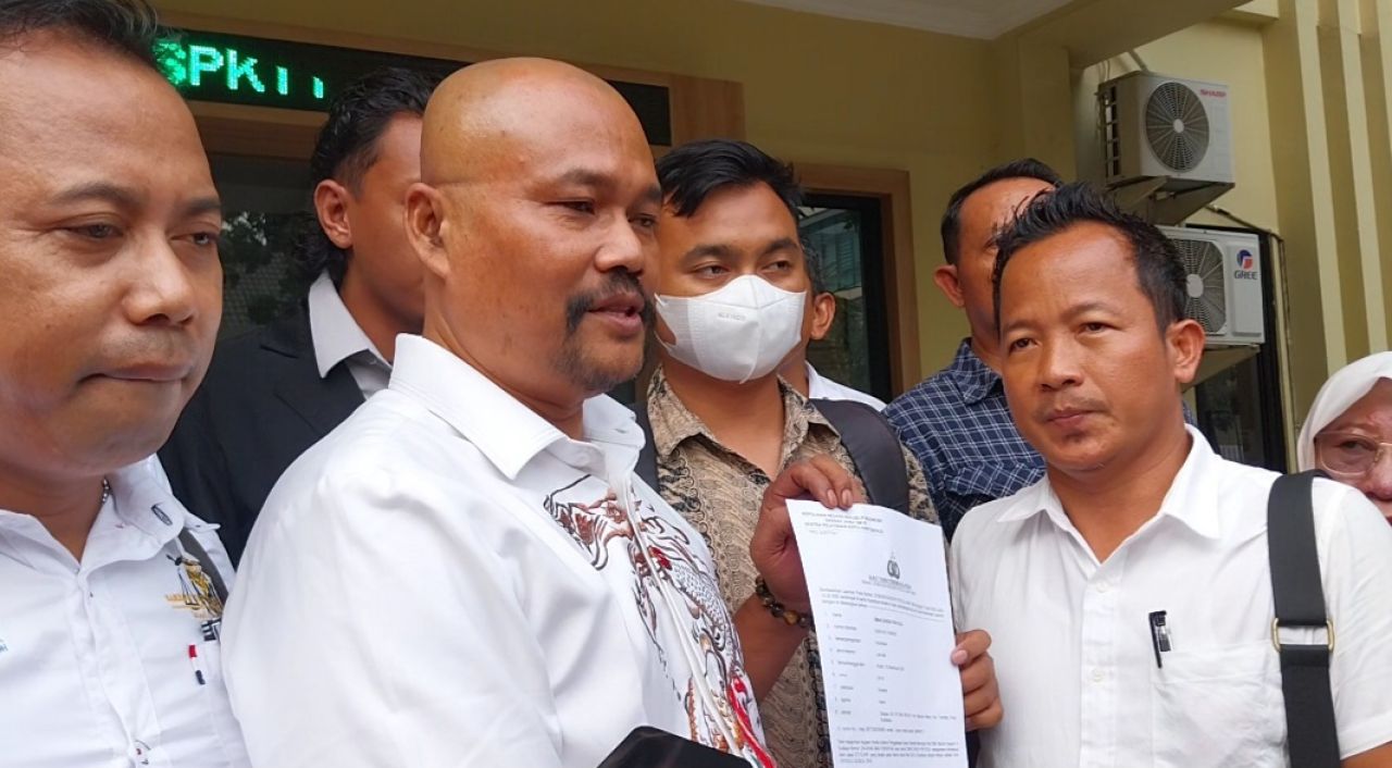 Pelapor DS (bermasker) didampingi kuasa hukumnya Edi Tarigan menunjukkan bukti laporan ke SPKT Polda Jatim
