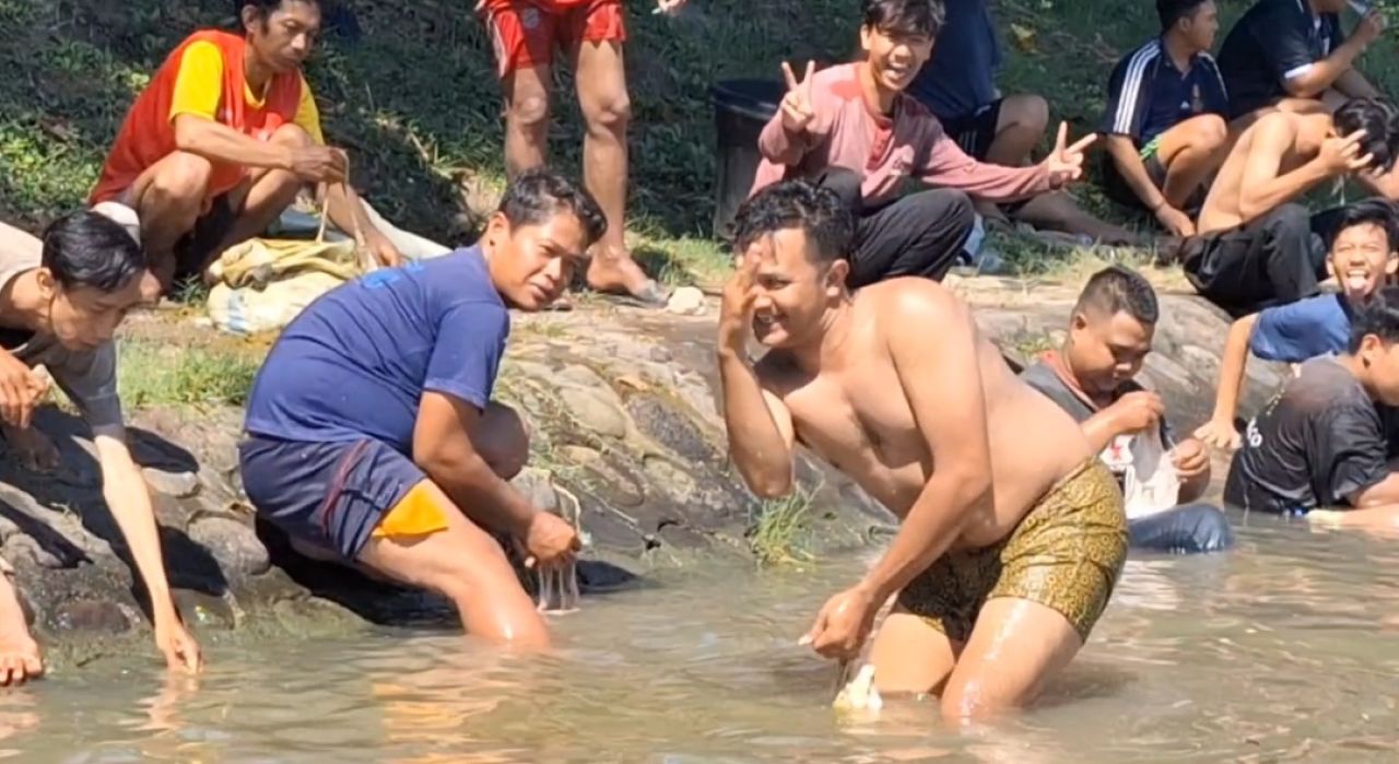 Warga sedang membersihkan organ dalam hewan kurban di Sungai Kalimas