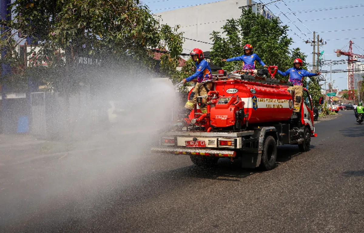 Redam Debu Proyek dan Suhu Panas, Damkar Surabaya Intensifkan Pembasahan Jalan