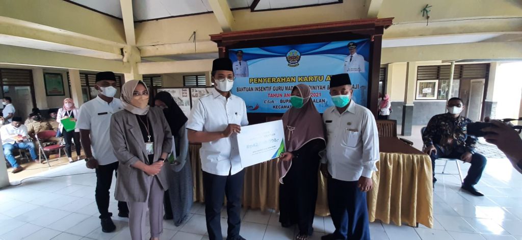 Bupati Bangkalan R. Abdul Latif Amin Imron dan Kepala BPJAMSOSTEK Madura Vinca Meitasari saat menyerahkan santunan JKM kepada ahli waris guru ngaji dan madin di Kecamatan Klampis dan Sepulu, Bangkalan, Rabu (1/12/2021).