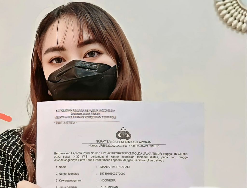 Imaniar menunjukkan bukti laporannya ke Polda Jatim