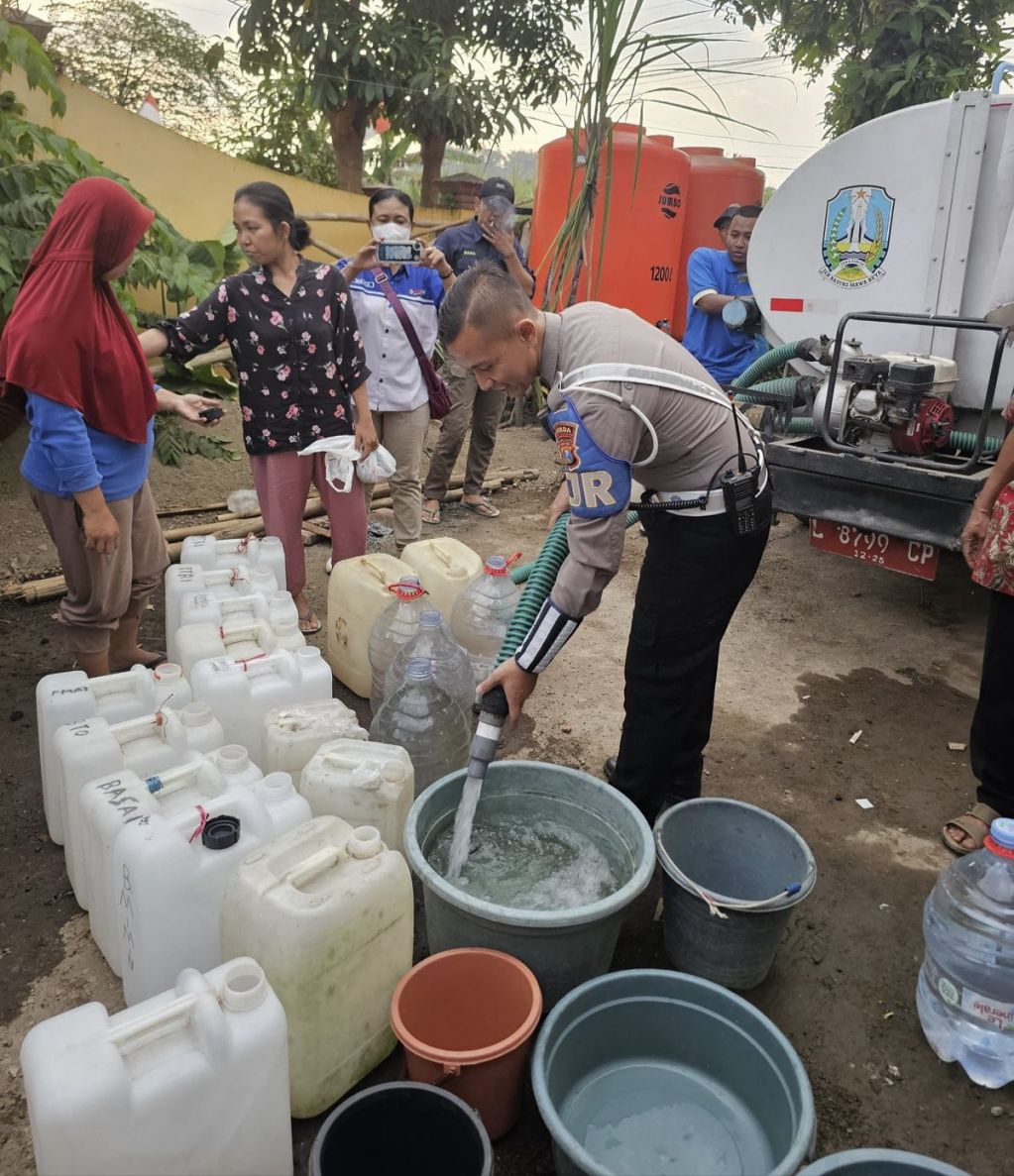 Anggota Ditlantas Polda Jatim saat distribusikan bansos air bersih