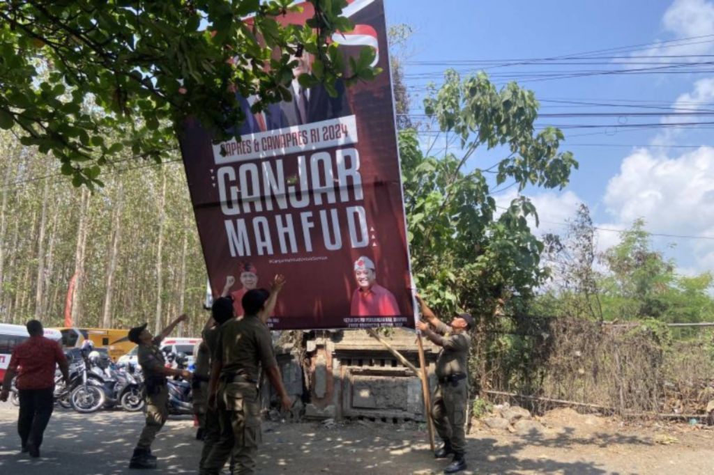 Satpol PP Bali mencopot baliho Ganjar-Mahfud ketika Presiden Jokowi melakukan kunjungan di Kabupaten Gianyar, Bali pada Selasa (31/10).