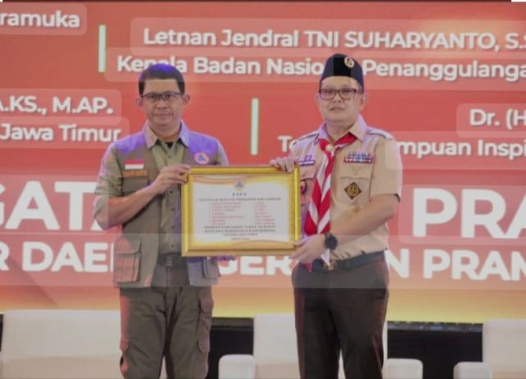 Kepala BNPB Letjen TNI Suharyanto (kiri) memberikan pin emas kepada Pj Gubernur Jatim Adhy Karyono dalam acara jumpa tokoh peringatan hari Pramuka ke-63 di Dyandra Convention Center Surabaya, Selasa (30/7/2024). 