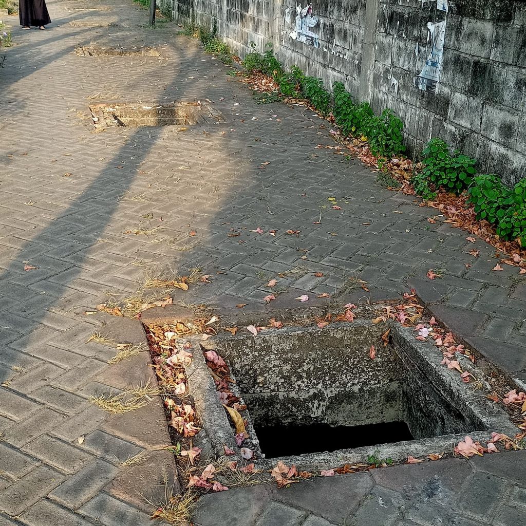 Tutup Saluran Air yang dibiarkan menganga di trotoar Pejalan kaki